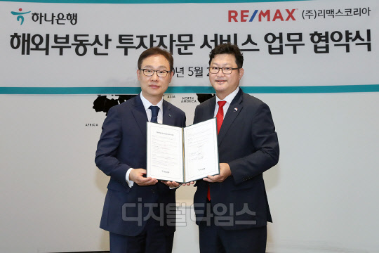 하나은행은 28일 오전 서울시 중구 을지로 본점에서 글로벌 부동산서비스업체 리맥스코리아 및 도우지엔과 해외 부동산 투자자문 서비스에 대한 업무협약을 체결했다. 협약식 체결 후 정원기 하나은행 자산관리사업단 단장(사진 왼쪽)과 신희성 리맥스코리아 대표이사(사진 오른쪽)가 기념촬영을 하고 있다.  하나은행 제공